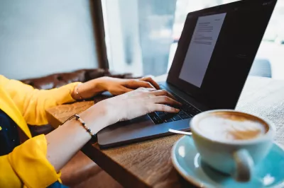 Apakah pekerjaan nomad digital Terbaik? : Perunding pemasaran digital yang mengusahakan Macbook pro di kafe dengan cawan kopi latte art cappuccino.